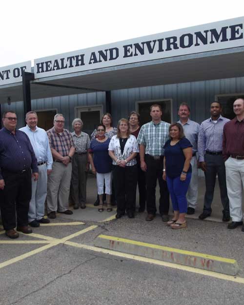 Kansas Department of Health and Environment (KDHE) team standing in front of the office, managing daycare costs and childcare regulations in Kansas.